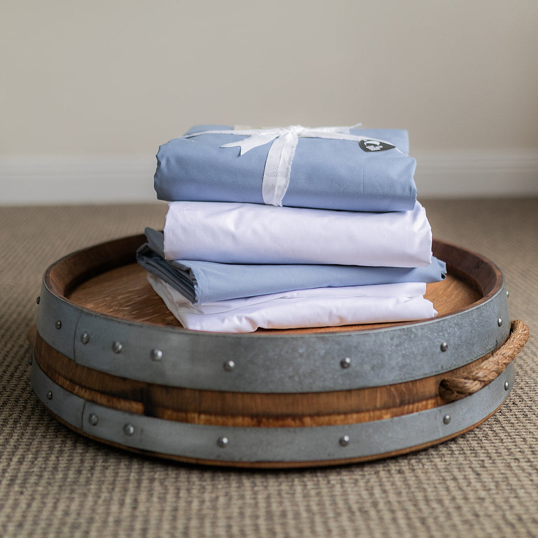Stack of SleepFROG fitted sheets on oak barrel 